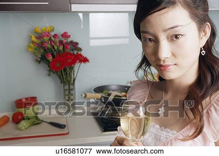 Stock Photo - Portrait of a young woman holding a glass of white wine. Fotosearch