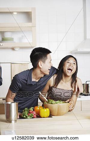 Young man embracing a young woman in the kitchen View Large Photo Image Stock Photo - Young man embracing a young woman in the kitchen. Fotosearch