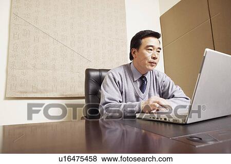 Businessman using a laptop View Large Photo Image Stock Photo - Businessman using a laptop. Fotosearch