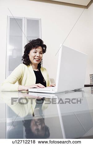 Stock Photo - Businesswoman using a laptop smiling. Fotosearch