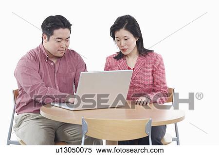 Close-up of a businessman and a businesswoman using a laptop View Large Photo Image Stock Photography - Close-up of a businessman and a businesswoman using a laptop. Fotosearch
