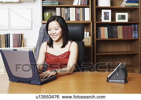 Close-up of a businesswoman using a laptop smiling View Large Photo Image Stock Photograph - Close-up of a businesswoman using a laptop smiling. Fotosearch