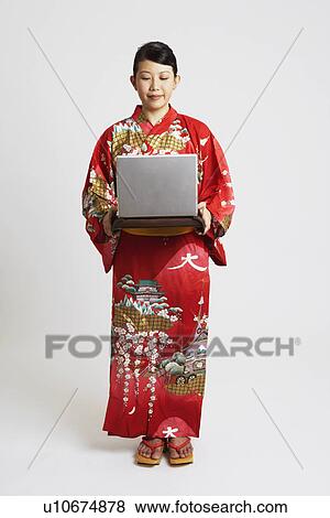Stock Photo - Close-up of a young woman holding a laptop on a tray. Fotosearch
