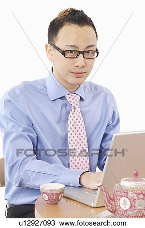 Portrait of a businessman using a laptop View Large Photo Image Stock Image - Portrait of a businessman using a laptop. Fotosearch
