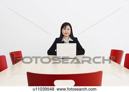 Stock Photo - Portrait of a businesswoman using a laptop in a board room. Fotosearch