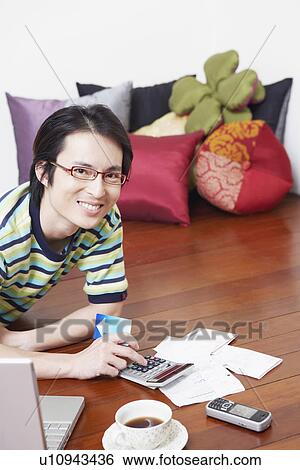 Portrait of a mid adult man calculating bills using a calculator View Large Photo Image Stock Photograph - Portrait of a mid adult man calculating bills using a calculator. Fotosearch