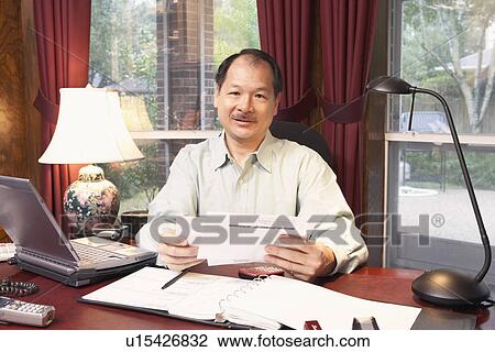 Stock Image - Portrait of a senior man holding a letter. Fotosearch