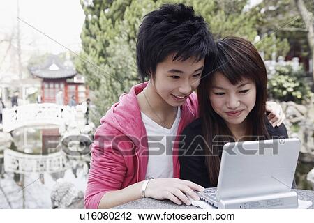 Close-up of a teenage boy and a young woman using a laptop View Large Photo Image Stock Image - Close-up of a teenage boy and a young woman using a laptop. Fotosearch