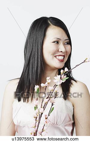 Close-up of a young woman holding flowers View Large Photo Image Stock Image - Close-up of a young woman holding flowers. Fotosearch