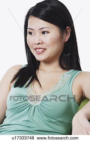 Close-up of a young woman looking away View Large Photo Image Stock Photo - Close-up of a young woman looking away. Fotosearch