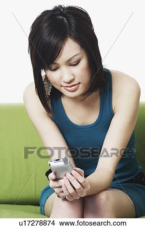 Close-up of a young woman operating a mobile phone View Large Photo Image Picture - Close-up of a young woman operating a mobile phone. Fotosearch