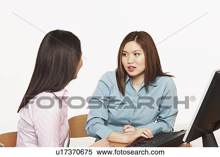 Stock Photography - Close-up of two businesswomen talking. Fotosearch