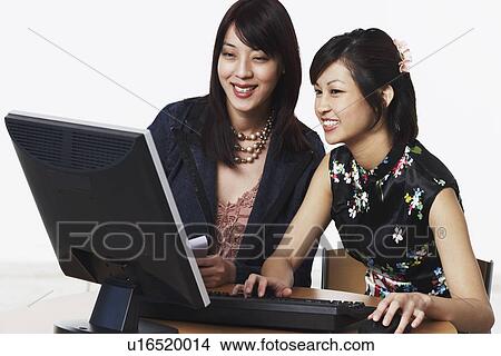 Picture - Close-up of two businesswomen using a computer. Fotosearch