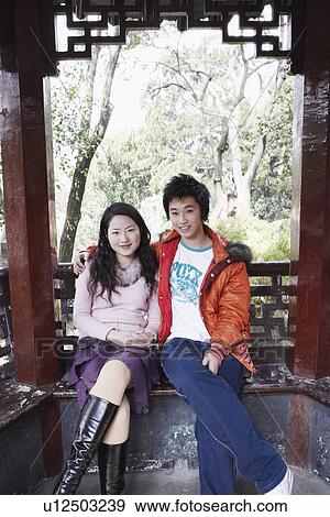 Stock Photo - Portrait of a teenage boy sitting with a young woman smiling. Fotosearch