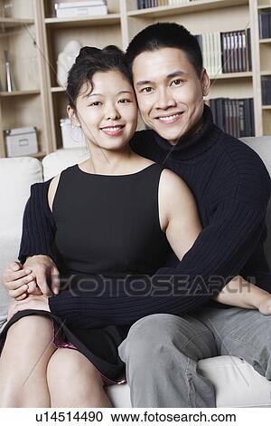 Stock Image - Portrait of a young man embracing a young woman smiling. Fotosearch