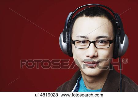 Stock Photo - Portrait of a young man wearing headphones. Fotosearch