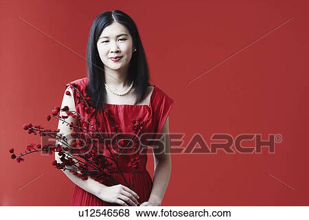 Portrait of a young woman holding flowers View Large Photo Image Stock Photo - Portrait of a young woman holding flowers. Fotosearch