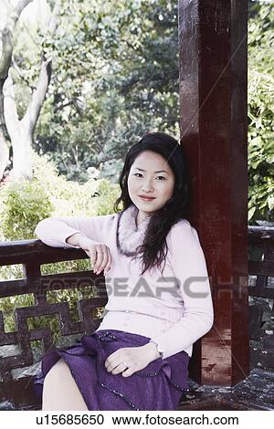 Stock Image - Portrait of a young woman sitting. Fotosearch