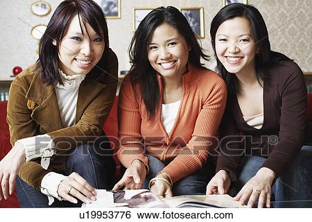 Portrait of three young women sitting together smiling View Large Photo Image Stock Photograph - Portrait of three young women sitting together smiling. Fotosearch
