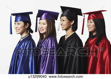 Stock Image - Side profile of four female graduates standing in a row. Fotosearch