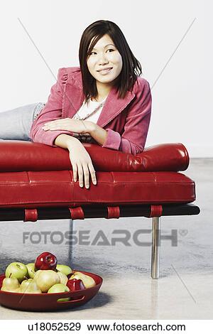 Stock Photo - Young woman smiling and looking away. Fotosearch