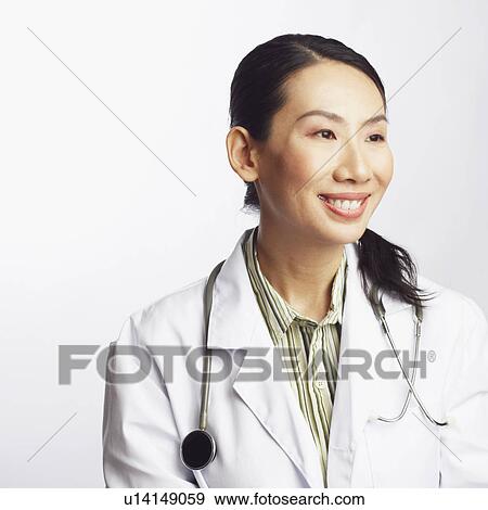 Close-up of a female doctor holding a clipboard and smiling View Large Photo Image Stock Photo - Close-up of a female doctor holding a clipboard and smiling. Fotosearch