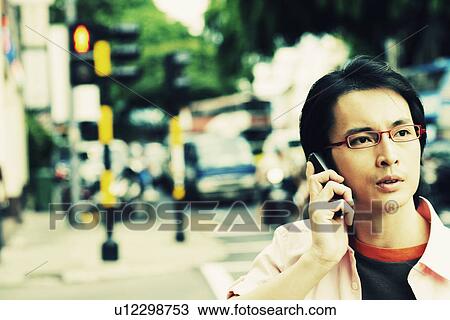Stock Image - Close-up of a mid adult man talking on a mobile phone. Fotosearch