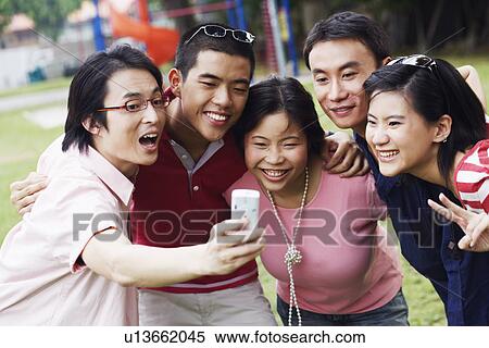 Five people looking at a mobile phone View Large Photo Image Stock Photography - Five people looking at a mobile phone. Fotosearch