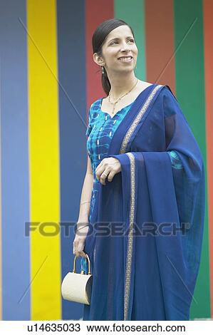 Stock Image - Mid adult woman holding a purse. Fotosearch