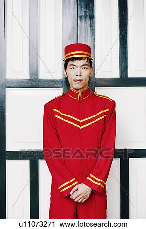Stock Image - Portrait of a bellhop standing. Fotosearch