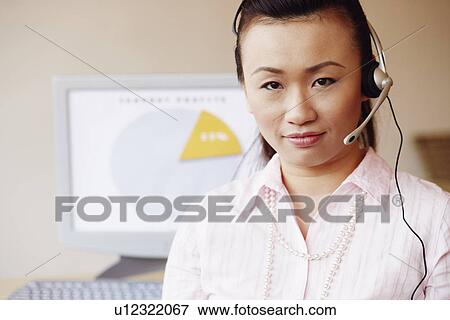 Portrait of a female customer service representative talking on a headset View Large Photo Image Stock Photo - Portrait of a female customer service representative talking on a headset. Fotosearch