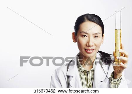 Portrait of a female doctor holding a graduated cylinder and smiling View Large Photo Image Stock Image - Portrait of a female doctor holding a graduated cylinder and smiling. Fotosearch