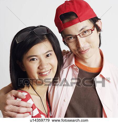 Stock Photo - Portrait of a young woman and a mid adult man smiling. Fotosearch