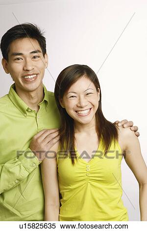 Stock Photography - Portrait of a young woman and a mid adult man posing. Fotosearch