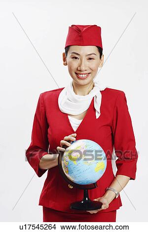 Portrait of an air stewardess holding a globe and smiling View Large Photo Image Picture - Portrait of an air stewardess holding a globe and smiling. Fotosearch