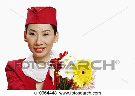 Portrait of an air stewardess holding flowers and smiling View Large Photo Image Stock Photo - Portrait of an air stewardess holding flowers and smiling. Fotosearch