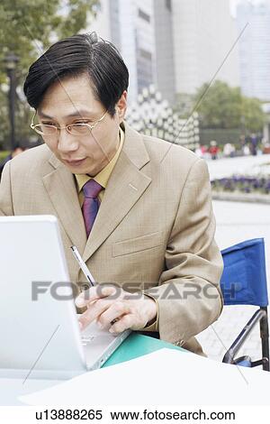 Close-up of a businessman using a laptop View Large Photo Image Stock Photography - Close-up of a businessman using a laptop. Fotosearch