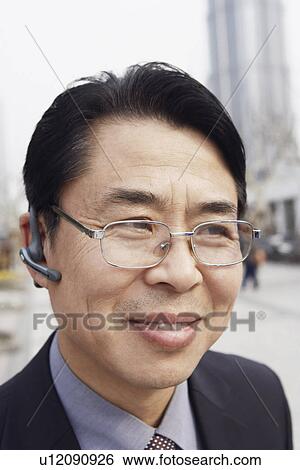 Close-up of a businessman wearing a hands free device smiling View Large Photo Image Stock Photograph - Close-up of a businessman wearing a hands free device smiling. Fotosearch