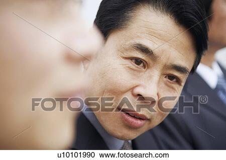 Stock Image - Close-up of a businessman with his colleagues. Fotosearch
