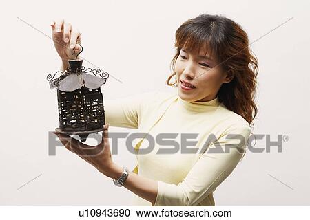 Close-up of a mature woman holding a lantern View Large Photo Image Stock Image - Close-up of a mature woman holding a lantern. Fotosearch