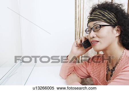 Close-up of a mature woman talking on a mobile phone View Large Photo Image Stock Photography - Close-up of a mature woman talking on a mobile phone. Fotosearch