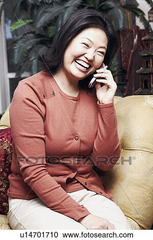 Stock Image - Close-up of a mature woman using a mobile phone. Fotosearch