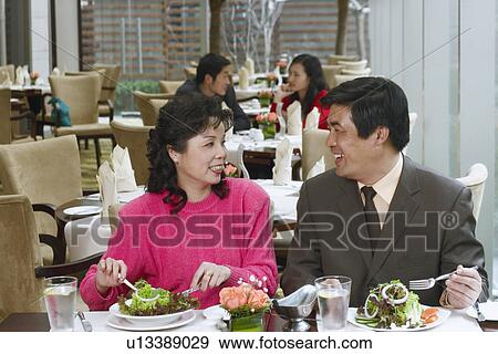 Mature couple sitting in a restaurant looking at each other View Large Photo Image Stock Photo - Mature couple sitting in a restaurant looking at each other. Fotosearch