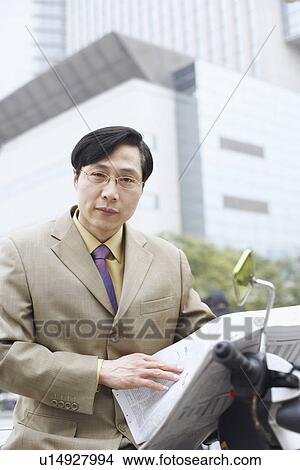 Picture - Portrait of a businessman holding a newspaper. Fotosearch