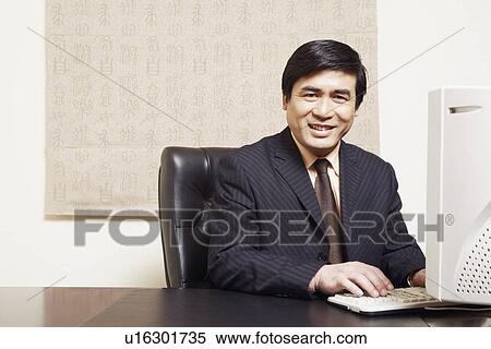 Portrait of a businessman sitting in an office smiling View Large Photo Image Stock Photography - Portrait of a businessman sitting in an office smiling. Fotosearch