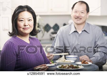 Portrait of a couple eating food View Large Photo Image Stock Image - Portrait of a couple eating food. Fotosearch