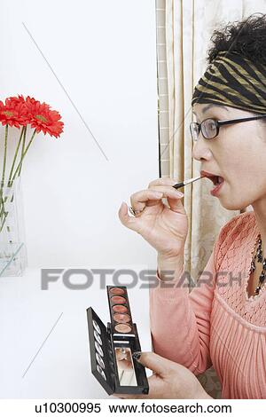 Side profile of a mature woman applying lipstick View Large Photo Image Stock Photography - Side profile of a mature woman applying lipstick. Fotosearch