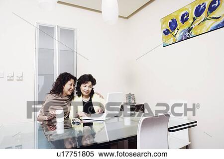 Two mature women using a laptop smiling View Large Photo Image Stock Photography - Two mature women using a laptop smiling. Fotosearch