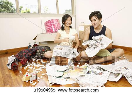 Close-up of a young couple sitting on the floor with crumpled paper View Large Photo Image Stock Photography - Close-up of a young couple sitting on the floor with crumpled paper. Fotosearch