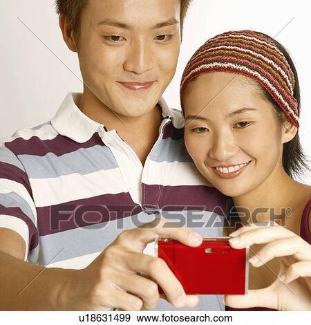 Close-up of a young couple taking a picture of themselves View Large Photo Image Stock Photo - Close-up of a young couple taking a picture of themselves. Fotosearch
